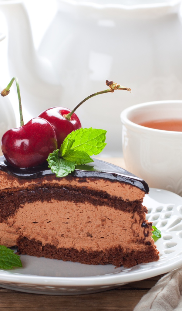 Торт с суфле в шоколаде с ягодами черешни на столе с чаем
