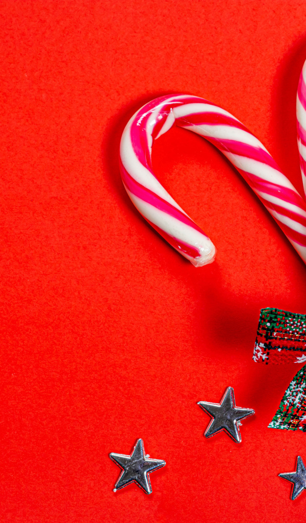 Рождественские леденцы с бантом на красном фоне
