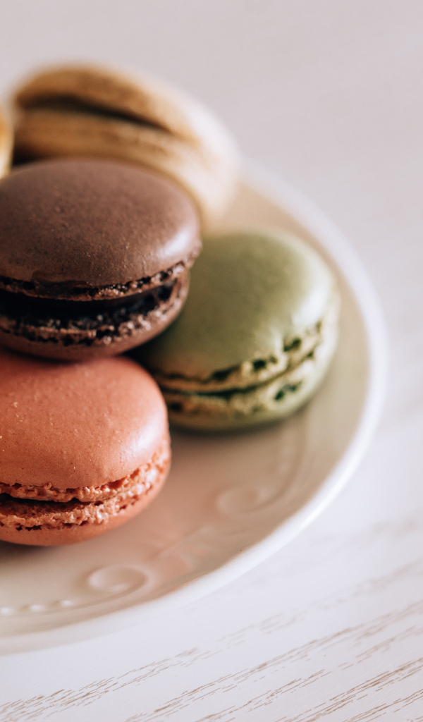 Разноцветный свежий десерт макарон на большой тарелке 