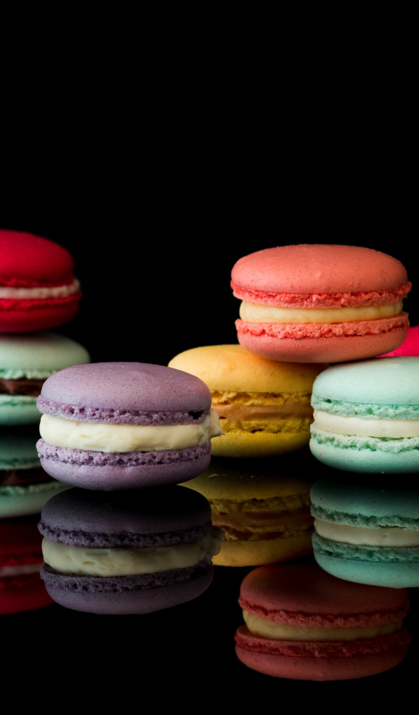 Разноцветный десерт макарун на черном фоне