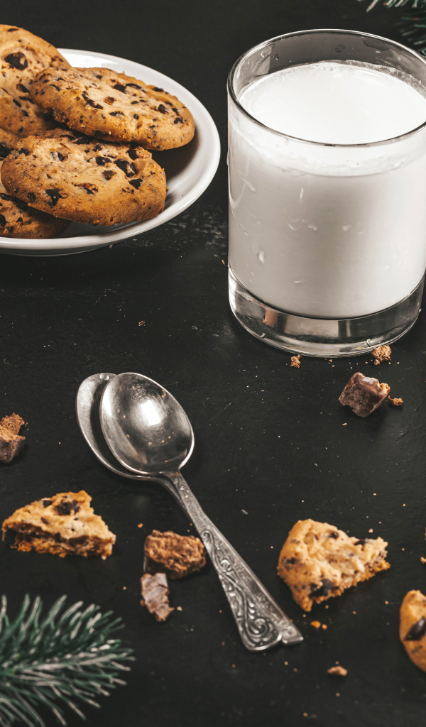 Печенье на столе с молоком и еловыми ветками