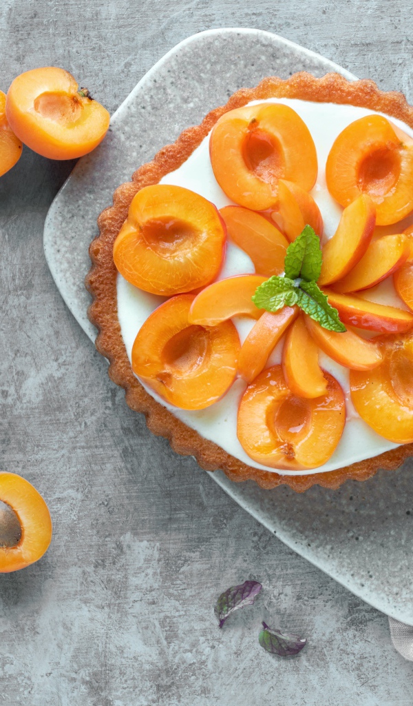 Пирог с кремом и абрикосами на столе 