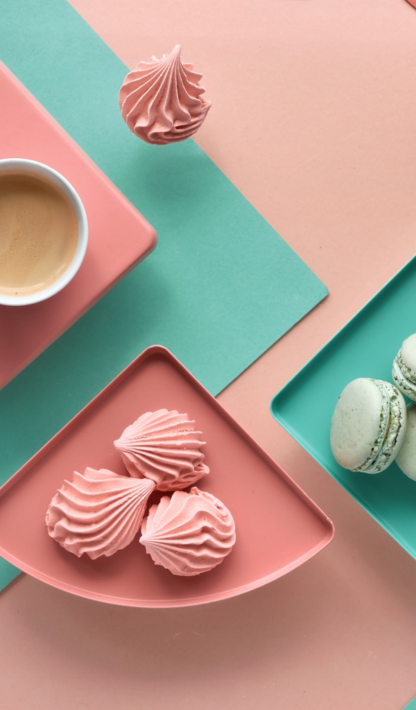 Чашка какао на столе с зефиром и десертом макарон 