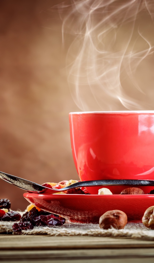 Чашка горячего кофе на столе с сухофруктами