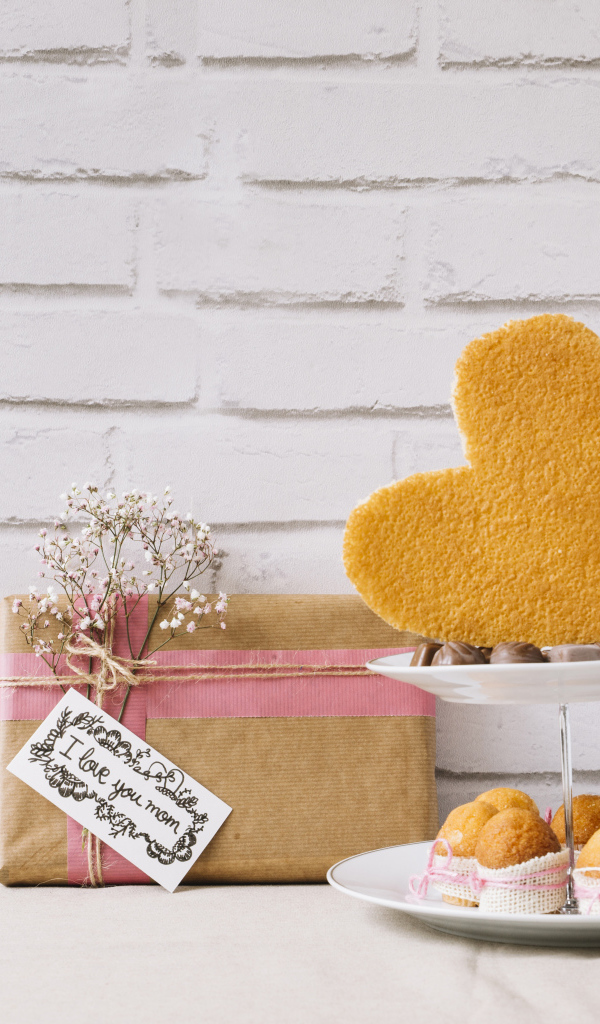 Кексы на тарелке на столе с подарком для любимой 