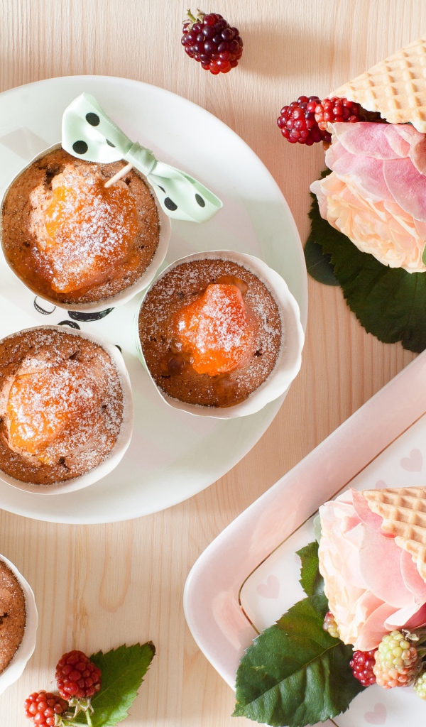 Вкусные кексы с абрикосом на столе с вафельными рожками с розой и ежевикой