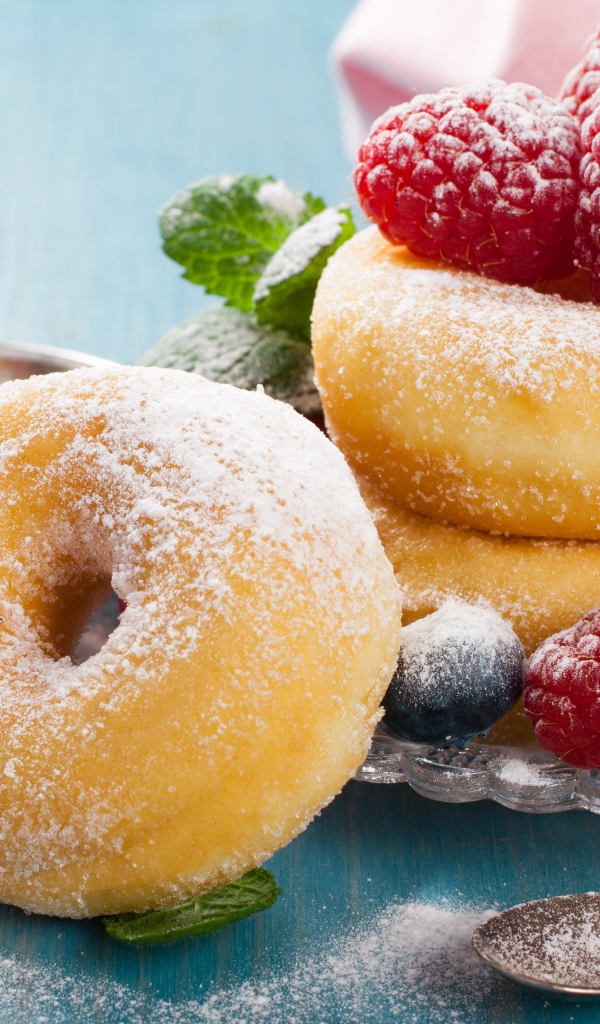 Вкусные пышные пончики с ягодами черники и малины с сахарной пудрой 