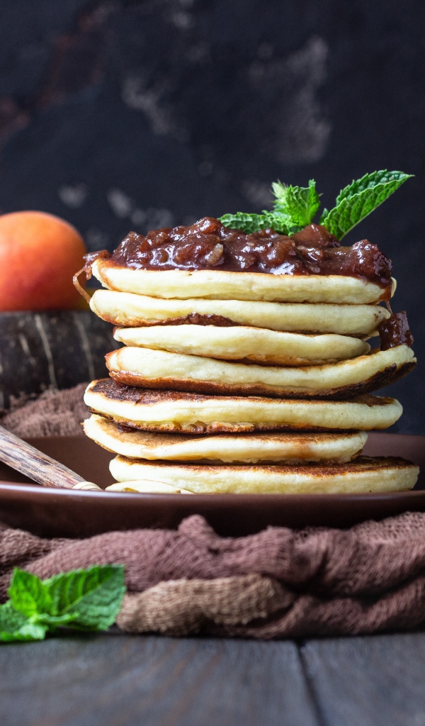 Вкусные оладьи на тарелке с джемом