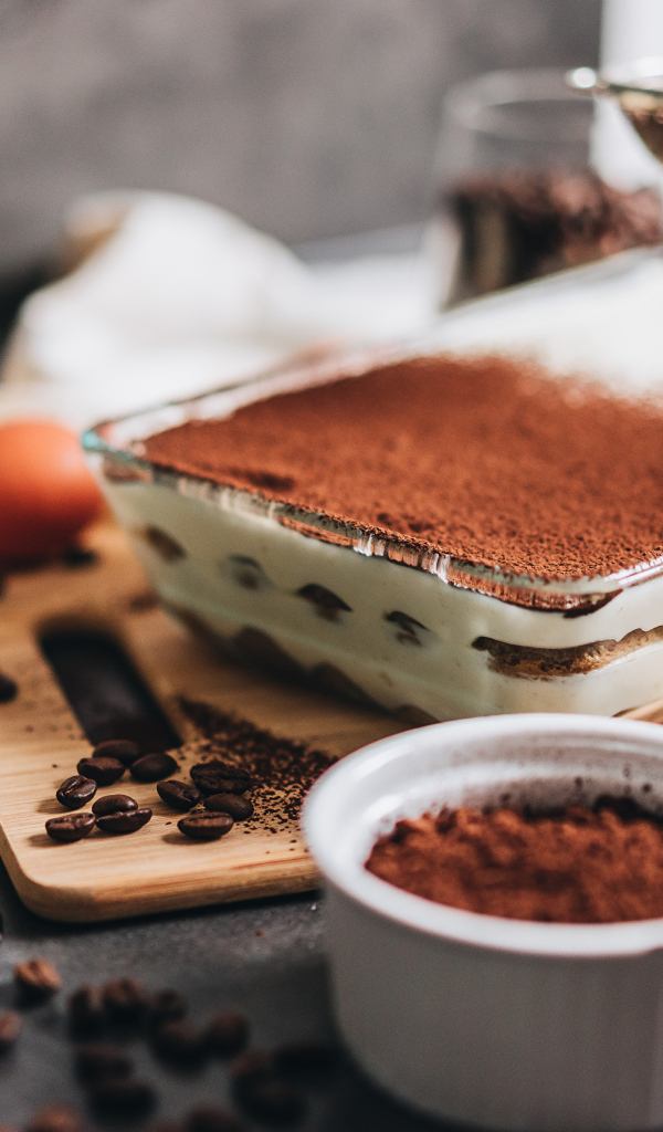 Десерт тирамису на столе с какао 