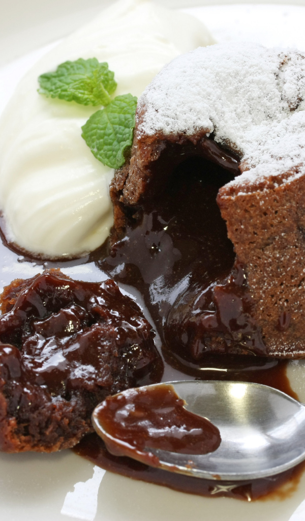 Десерт с шоколадом и сливками на белой тарелке 