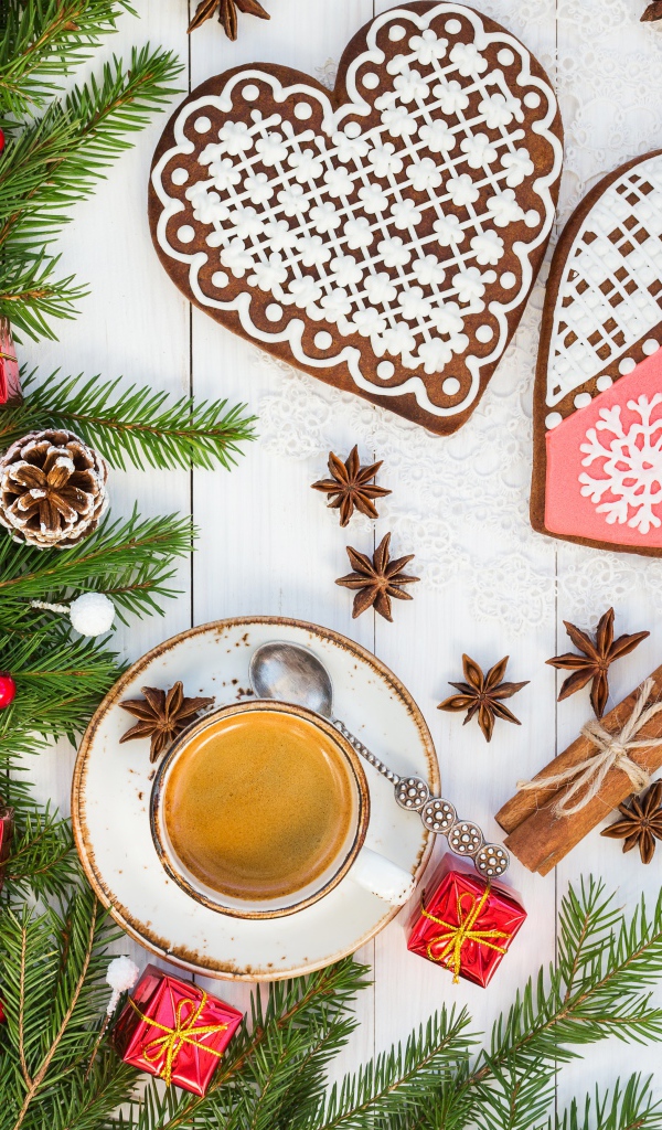 Печенье в форме сердца на столе с чашкой кофе и еловой веткой