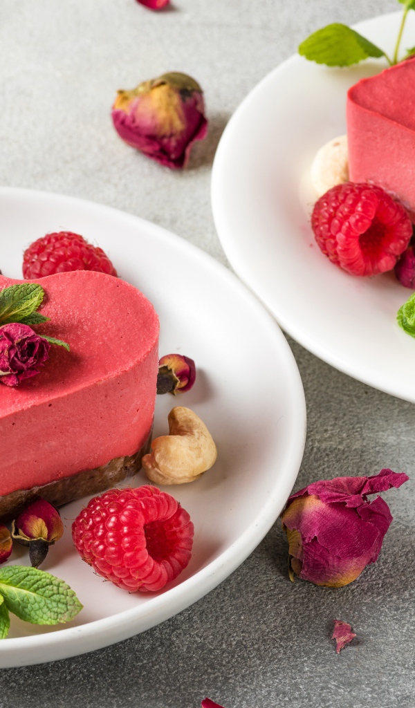 Фруктовое суфле в форме сердца на тарелке с малиной и орехами 