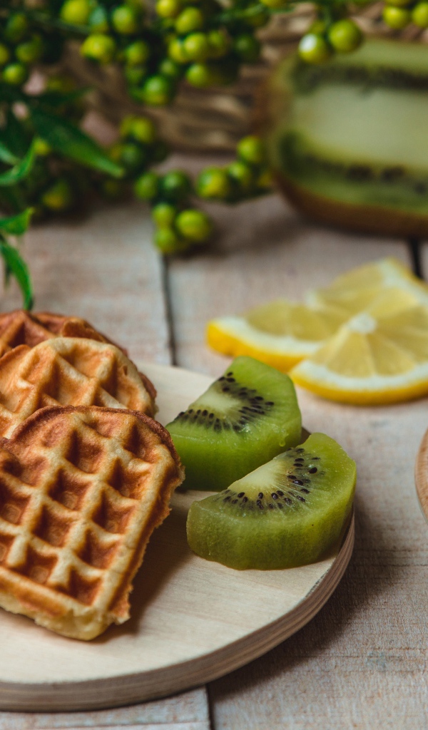 Вафли в форме сердца на доске с киви и чашкой кофе