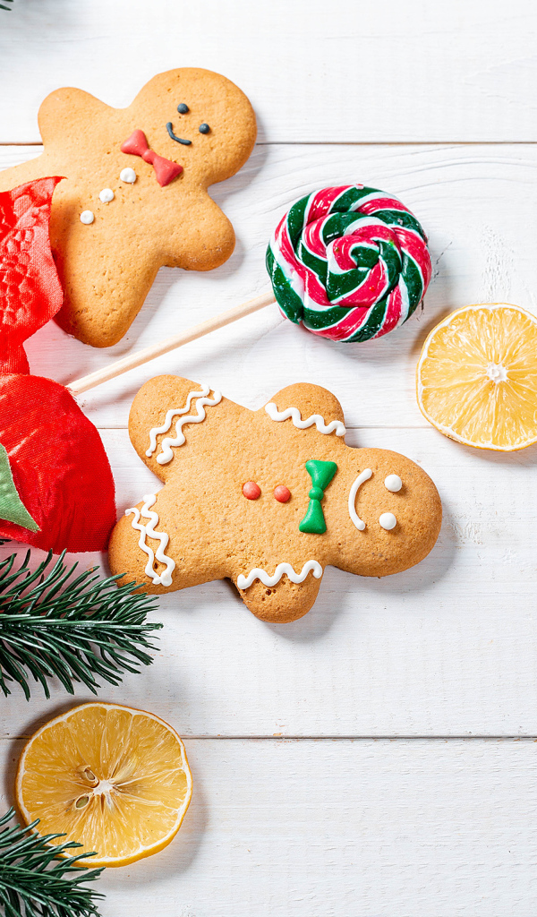 Праздничное печенье с леденцом и еловой веткой на столе 