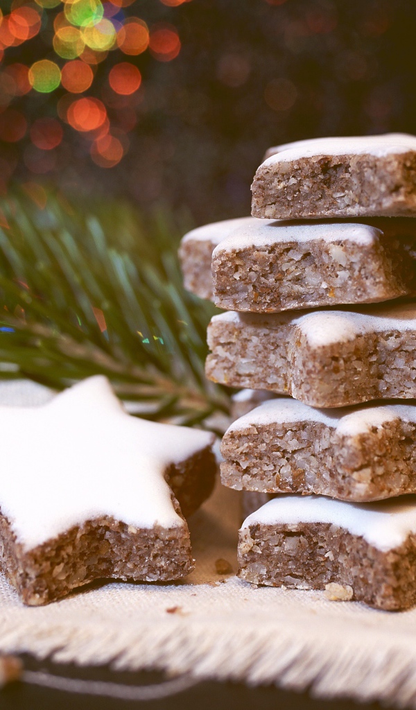 Печенье с глазурью на столе с еловой веткой 