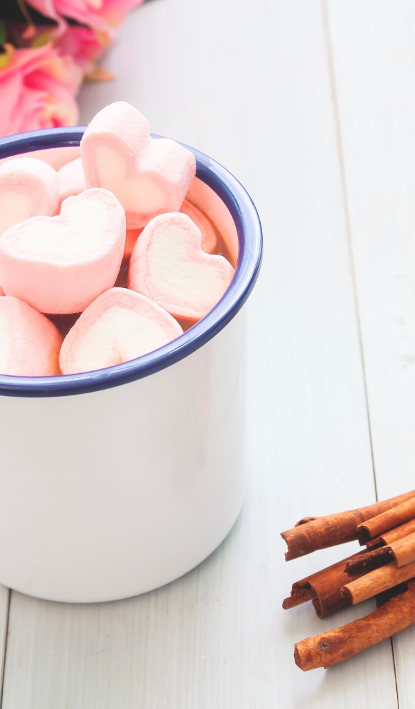 Железная чашка какао с маршмеллоу на столе с корицей 