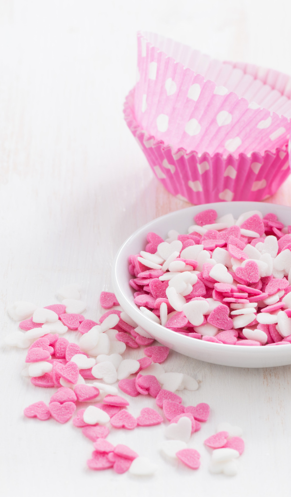 Маленькие белые и розовые сердечки на столе 