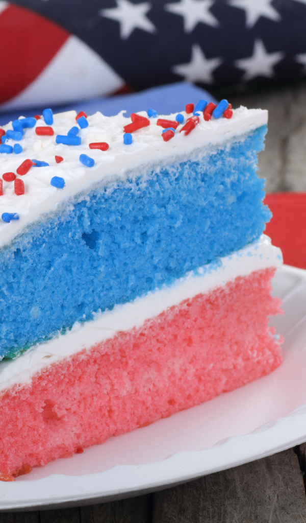 Разноцветный торт на тарелке с кремом