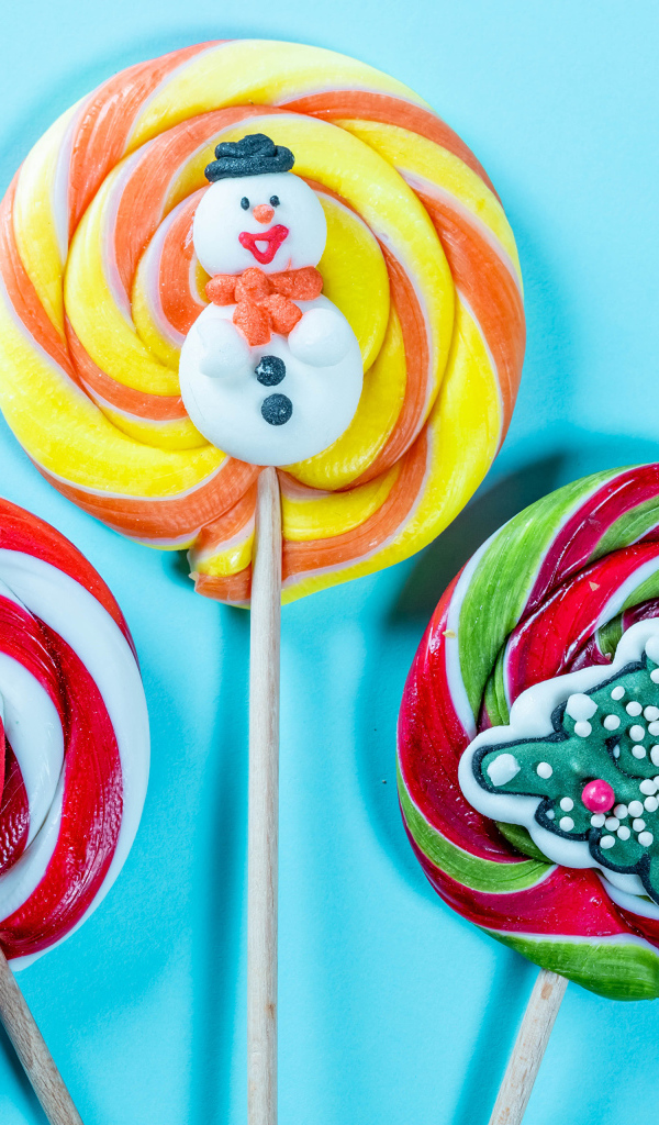 Разноцветные леденцы на палочках на голубом фоне