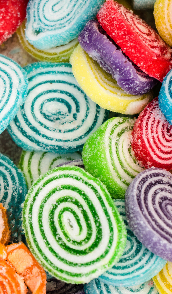 Разноцветный спиральный мармелад в сахаре крупным планом