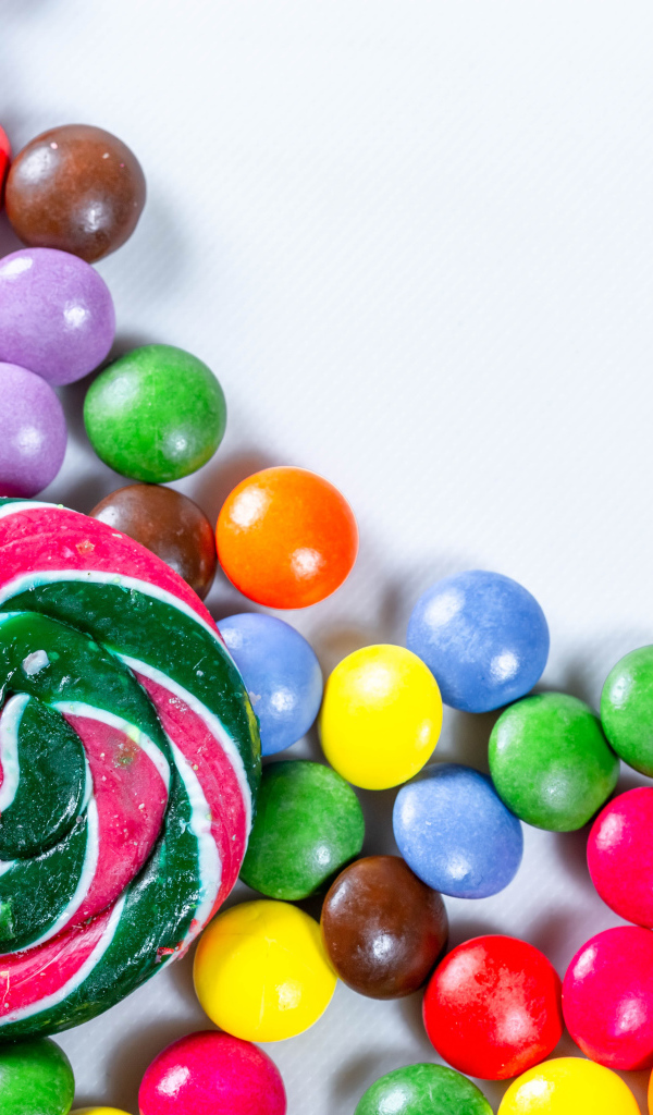 Разноцветные конфеты в глазури и карамель на белом фоне 