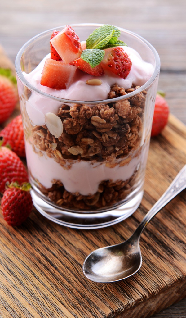 Овсяные хлопья в стакане с йогуртом и ягодами клубники