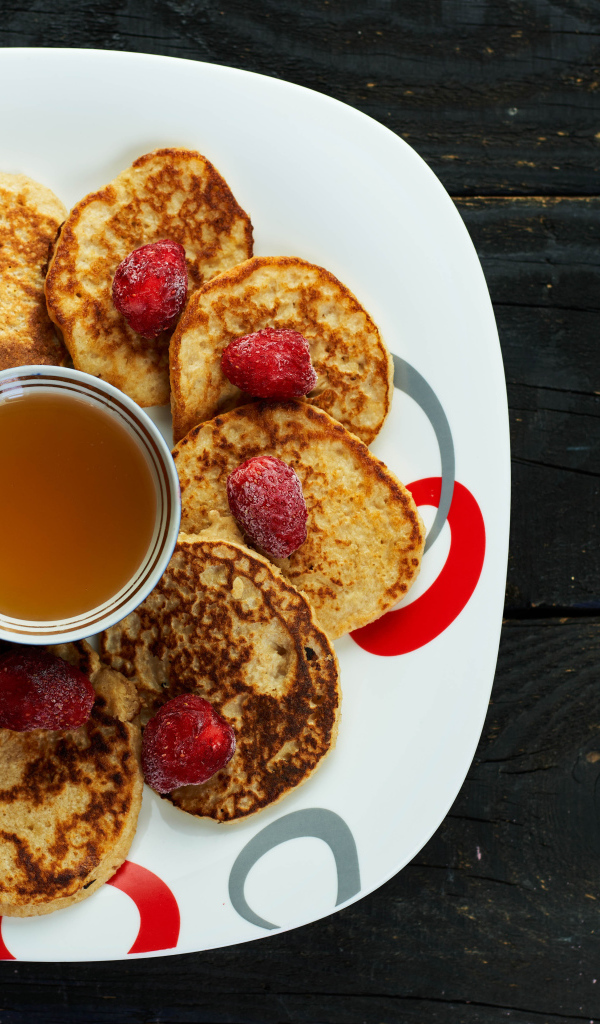 Оладьи на тарелке с клубникой и медом