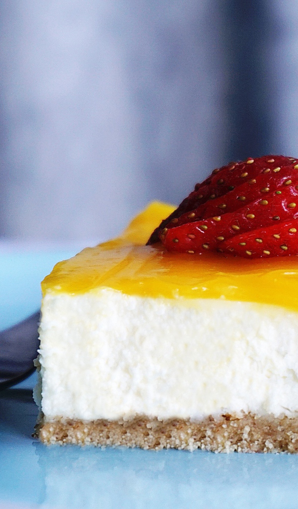 Кусок чизкейка с кремом и спелой клубникой 