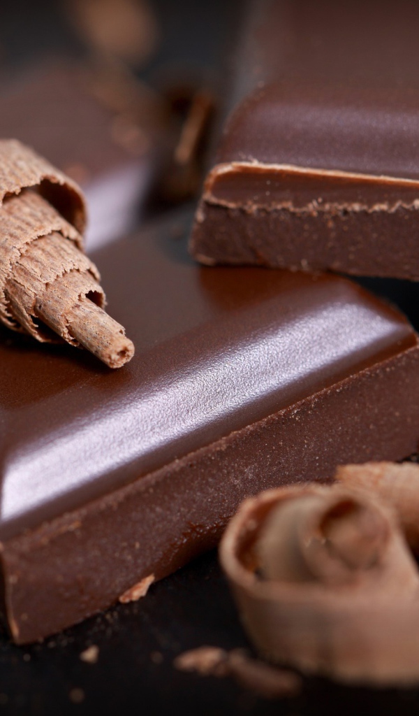 Куски шоколада и стружка на столе крупным планом