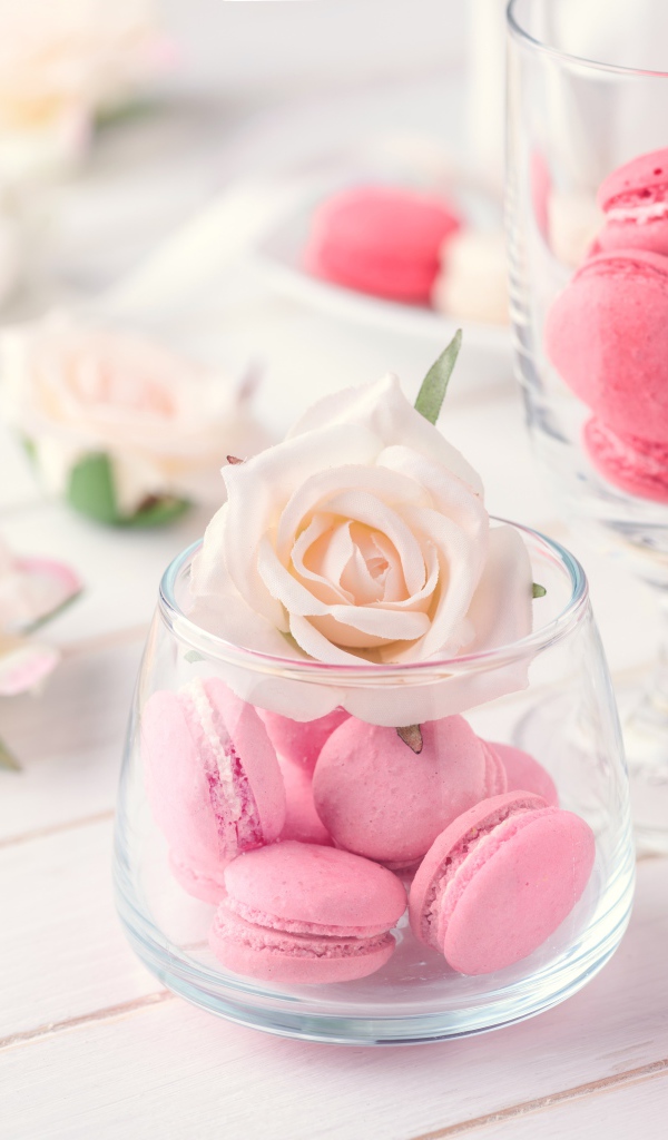Розовый десерт макарон в вазе с розой