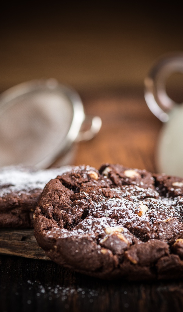 Вкусное шоколадное печенье с орехами на столе с молоком