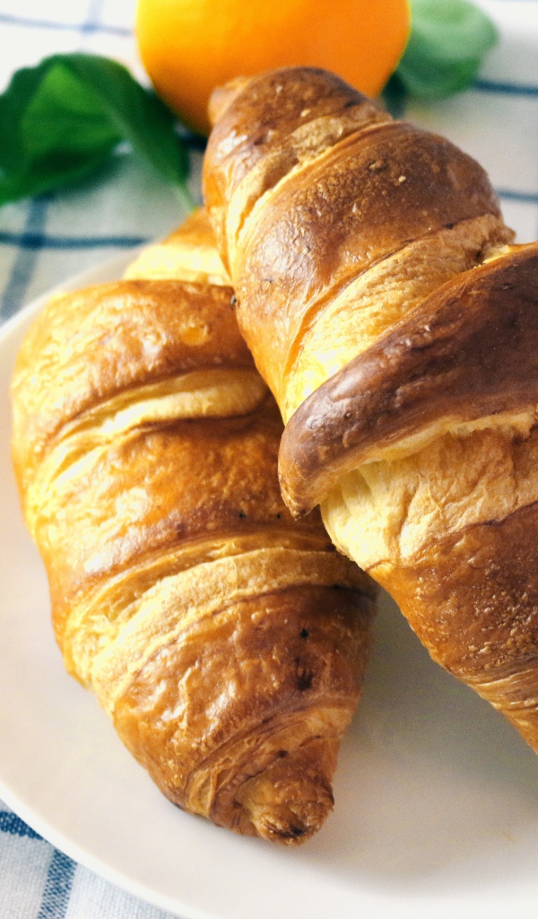 Два круассана на столе с джемом и соком