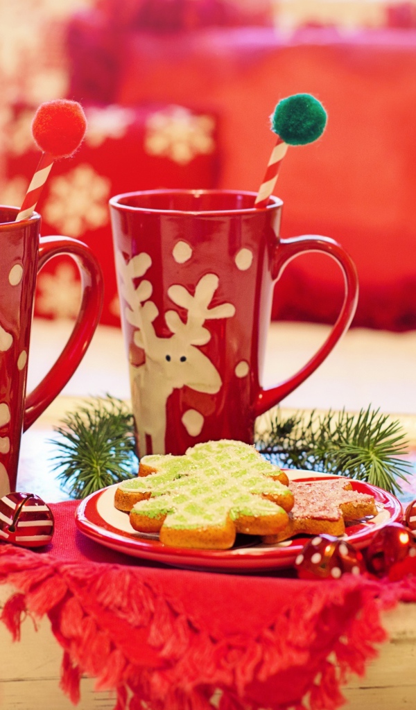Две красные чашки с печеньем на столе на Рождество 