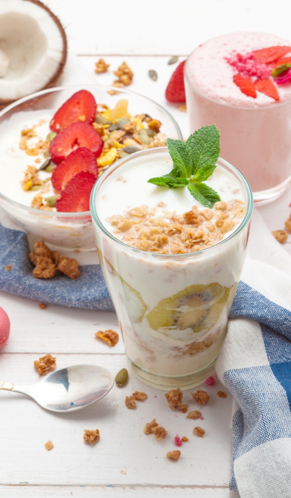 Йогурт с хлопьями и ягодами клубники на столе 