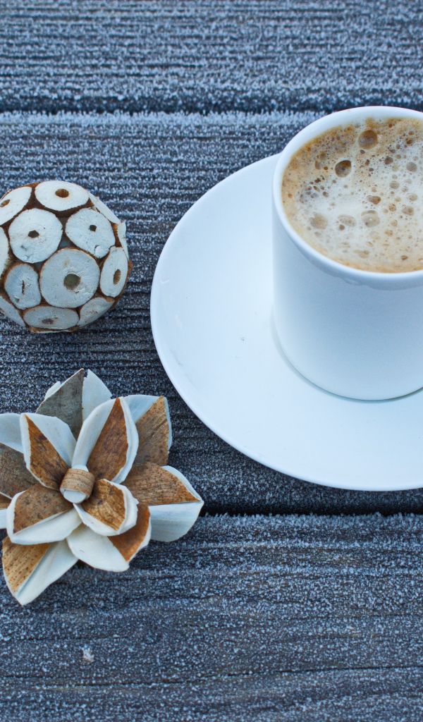 Чашка горячего кофе на покрытом инеем столе 