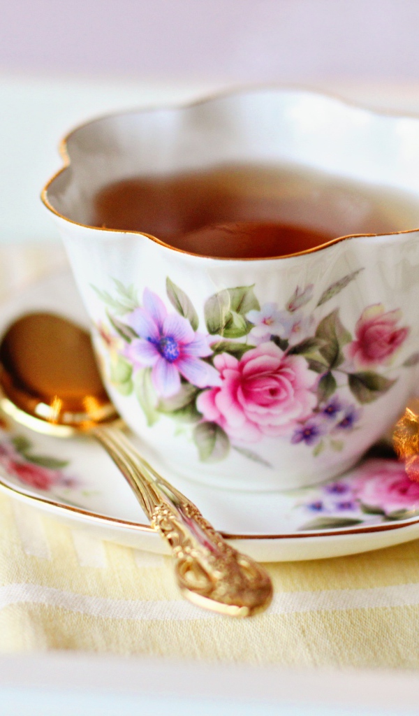 Красивая чашка чая на столе с ложкой