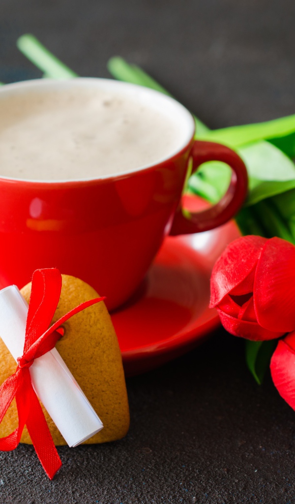 Букет тюльпанов и чашка кофе с печеньем на столе