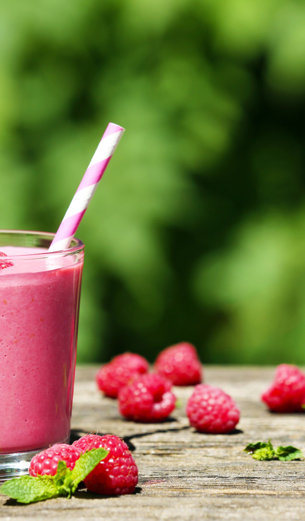 Коктейль в стакане с трубочкой и ягодами малины