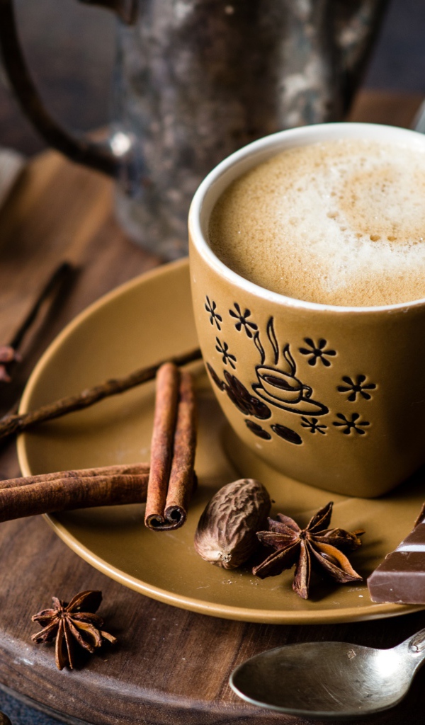 Чашка капучино на блюдце со специями