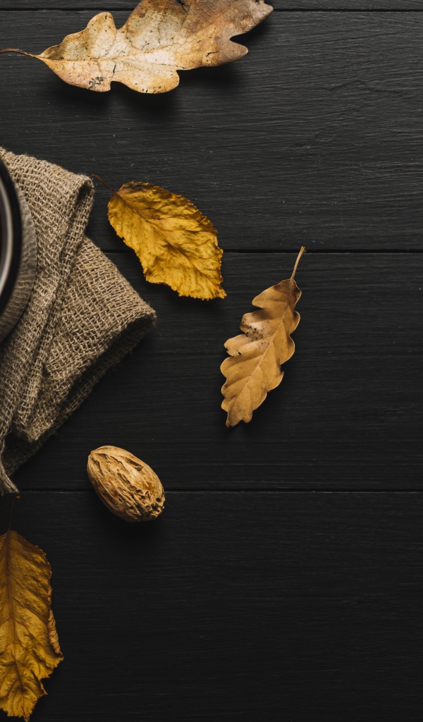 Чашка кофе на черном столе с листьями