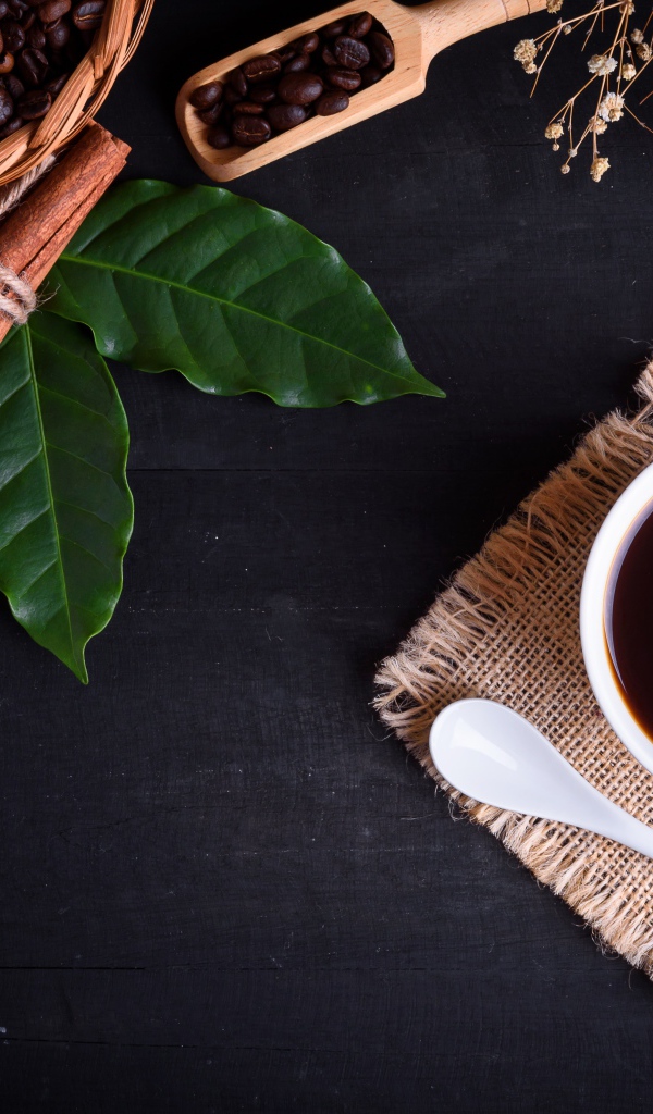 Чашка кофе на столе с корицей и лавровым листом