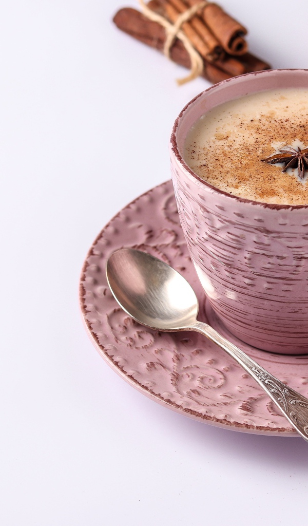 Чашка кофе на столе с корицей, бадьяном и  имбирем на белом фоне 