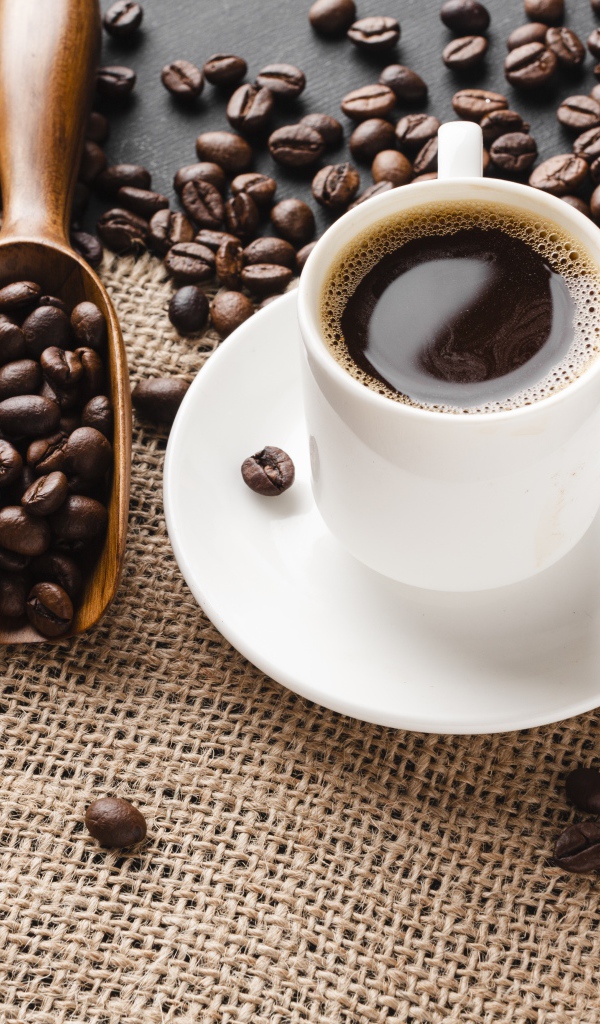 Чашка кофе на столе с зернами 