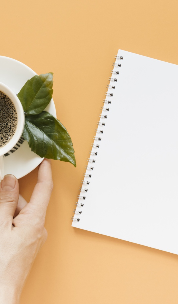 Чашка кофе на столе с блокнотом