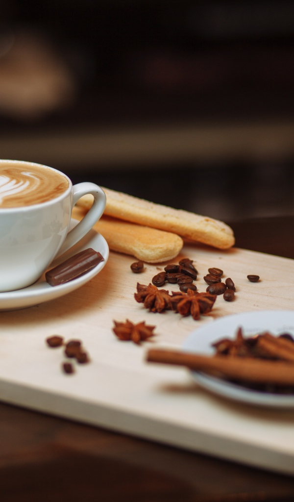 Чашка кофе на столе со специями и печеньем