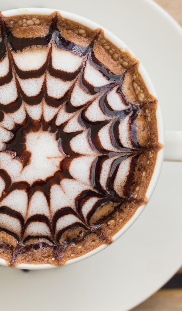 Чашка кофе с рисунком на пене на столе