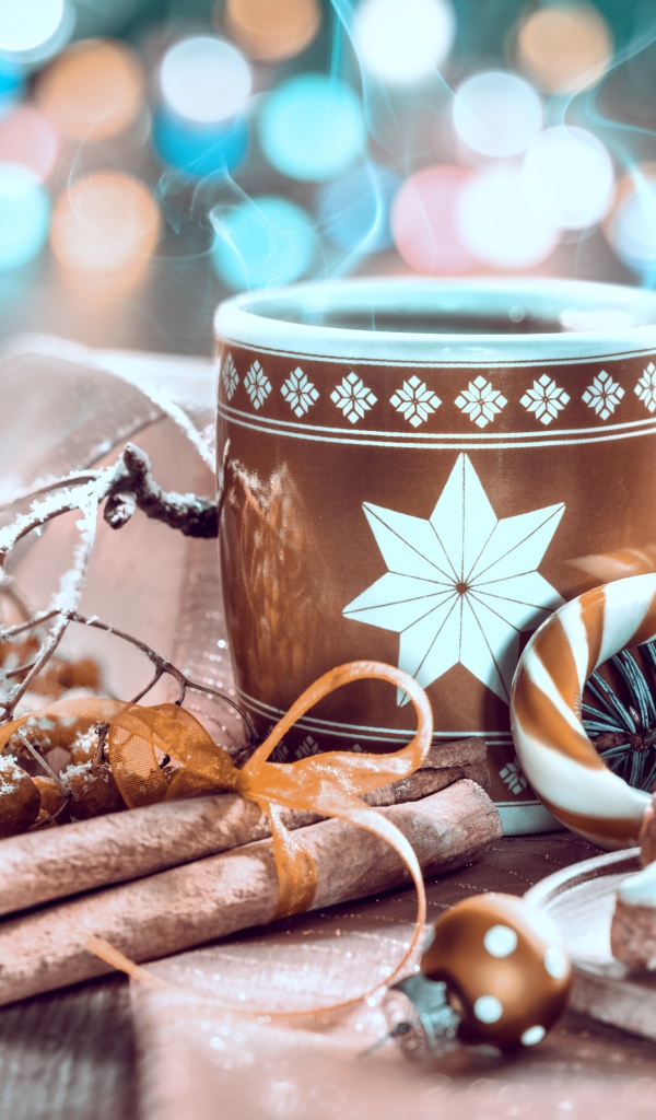 Чашка горячего кофе на столе с корицей и печеньем и веткой рябины