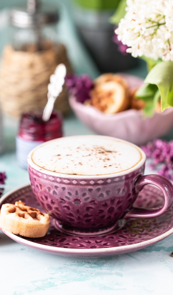 Чашка вкусного кофе с печеньем на столе с букетом сирени