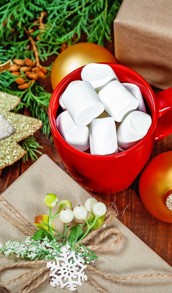 Чашка с маршмеллоу на столе с подарком, печеньем и еловой веткой