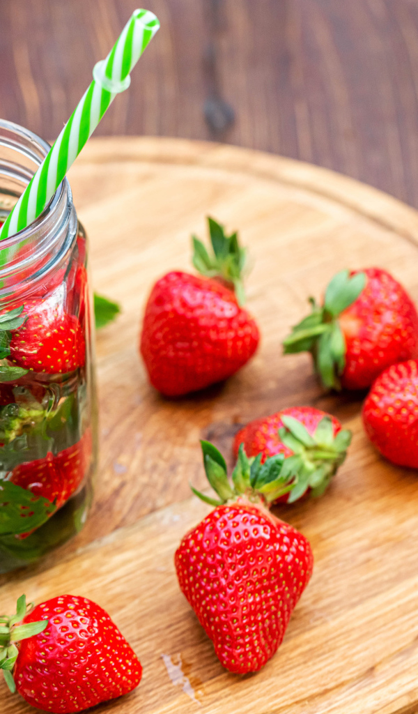 Напиток  в банке с ягодами клубники и трубочкой